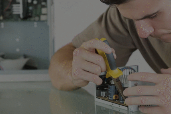A white male students builds a computer component in the lab