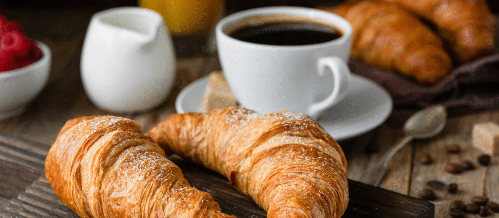 A breakfast selection including croissants and a hot cup of coffee