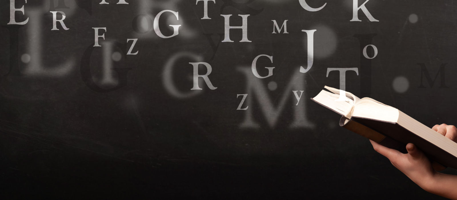 Open book with letters of alphabet in the background