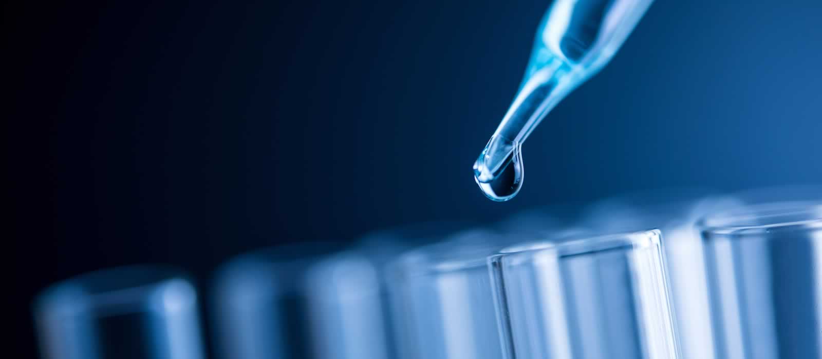 A pipette is used to drip a tiny sample of liquid into a test tube.