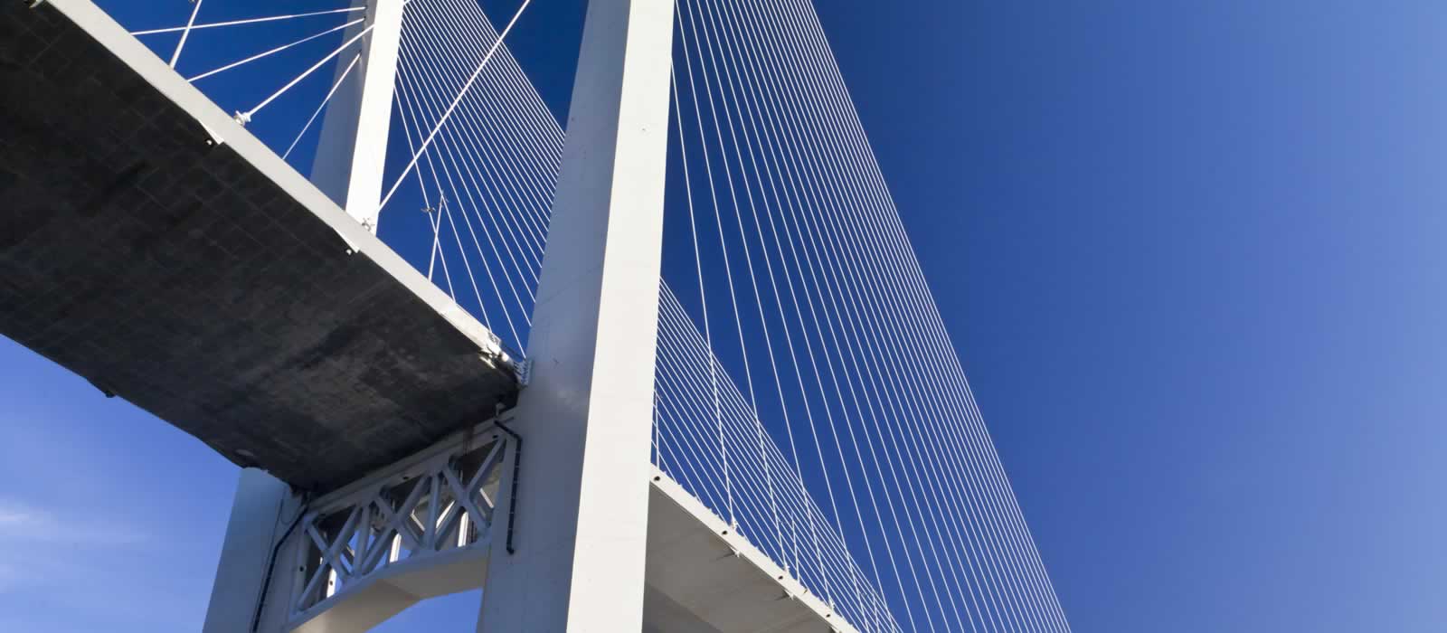 The elegant design of a suspension bridge, its cables soaring up to a single point at the apex ot the bridge. 