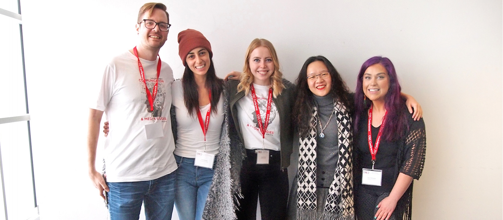 A group of very happy students of a range of racialized groups and gender identities, smiling for the camera.