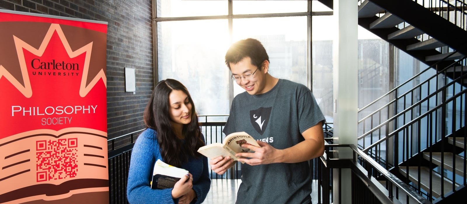Two students discussing a book