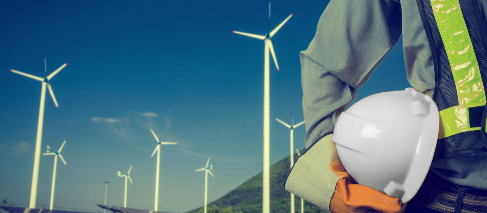 Wind, turbines and worker worker holding hard hat