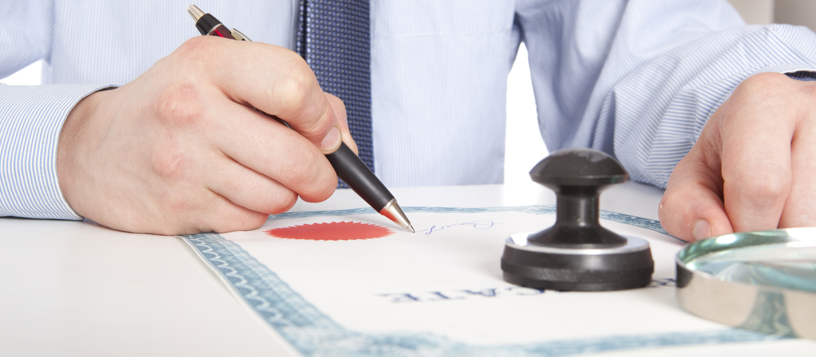 A man signing and stamping and official document